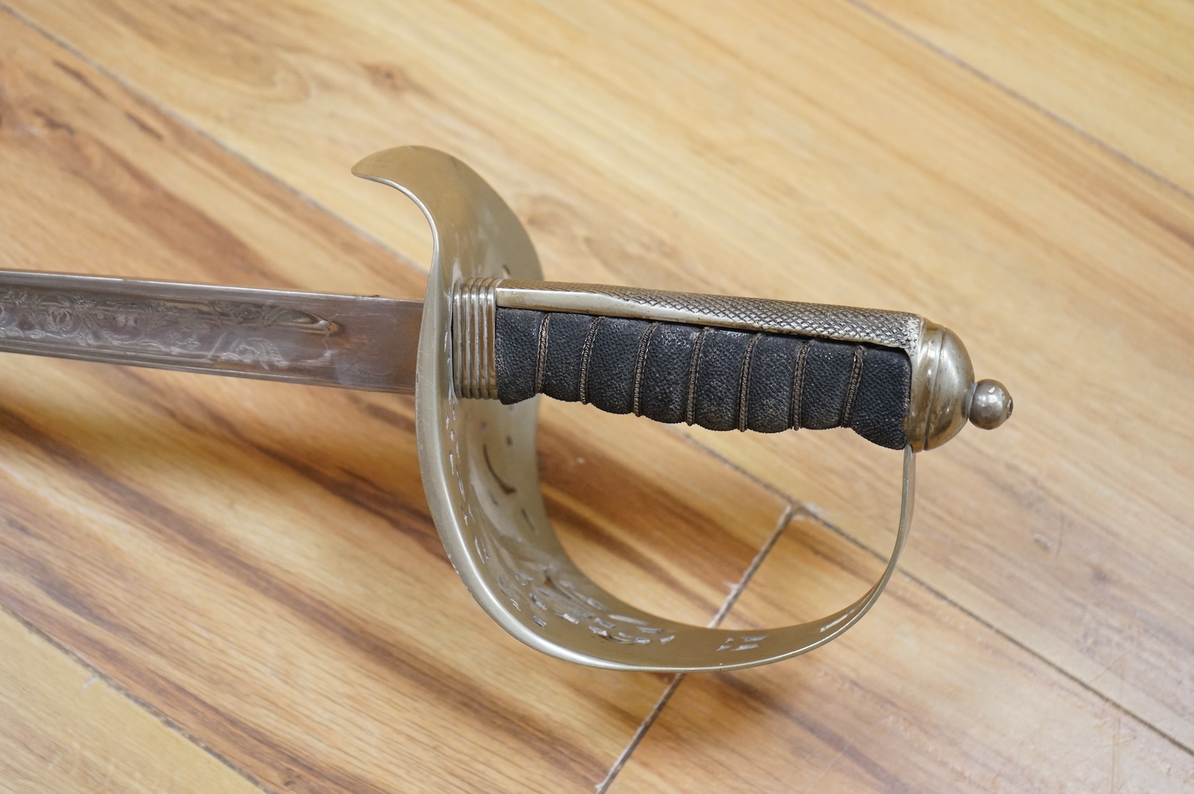 A George V 1897 pattern infantry officer’s sword, with regulation blade etched with the union flowers, Royal Arms and owners name; J.W. Reynolds, Dorrington, Lincoln, regulation nickel guard stamped ‘WH&S’ in minuscules,